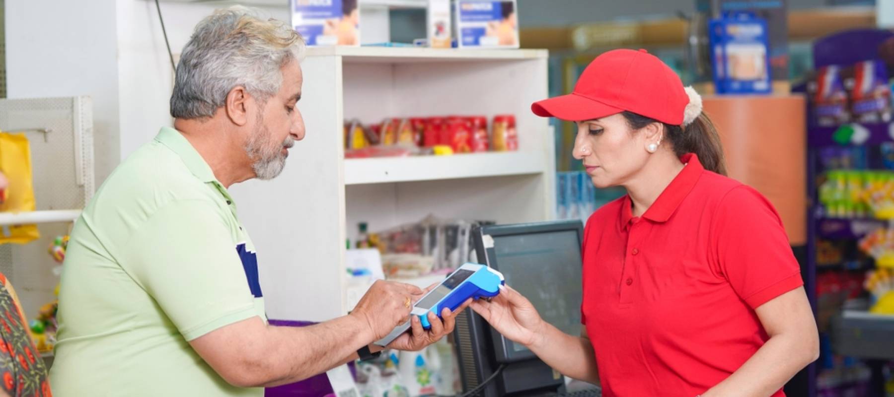 Senior paying at store with credit cad.